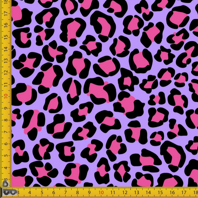 Leopard print fabric with pink and black spots on a purple background, measured by a ruler.