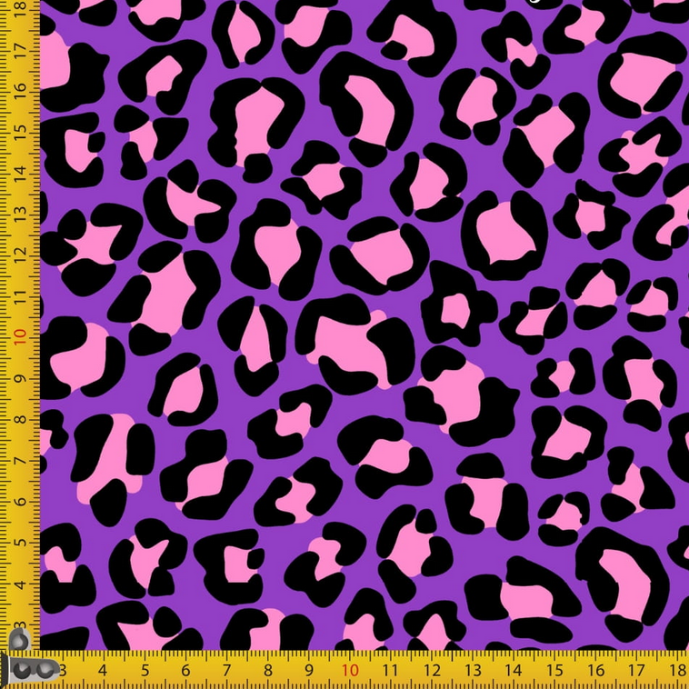 Fabric with pink and black leopard print on a purple background, measured by a yellow ruler.